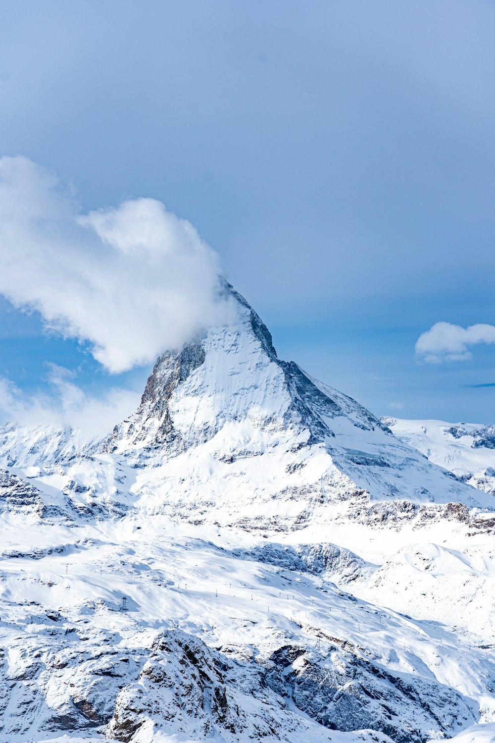 a mountain covered in snow under a blue sky