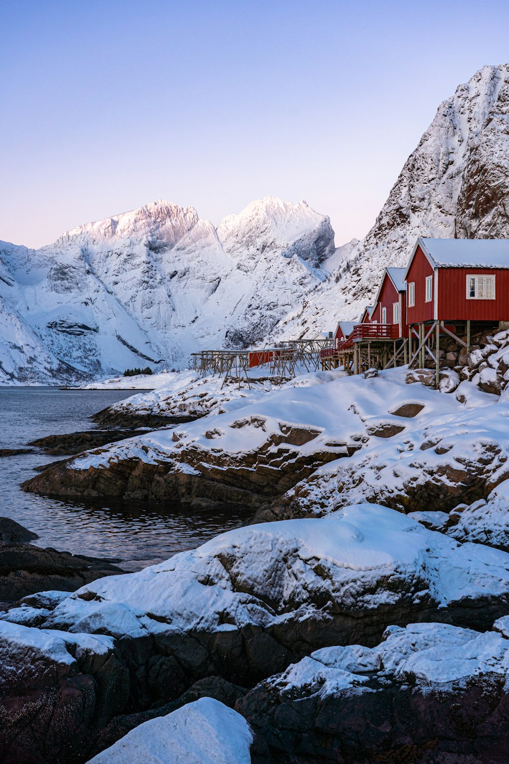 uma casa vermelha sentada no topo de uma montanha coberta de neve