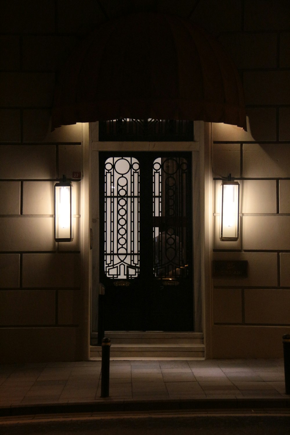 a black door and some lights on a building