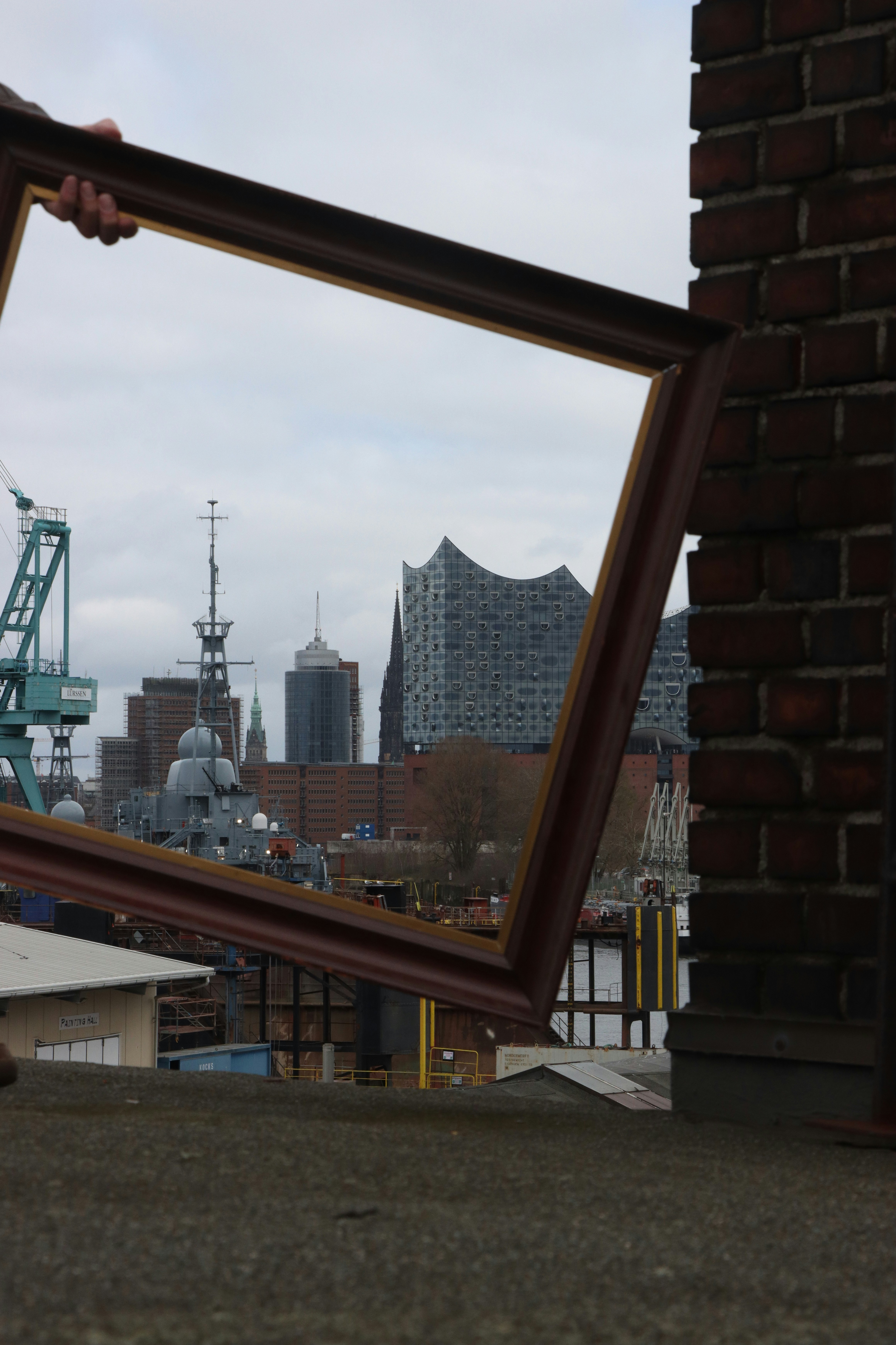 a person holding a picture frame with a city in the background