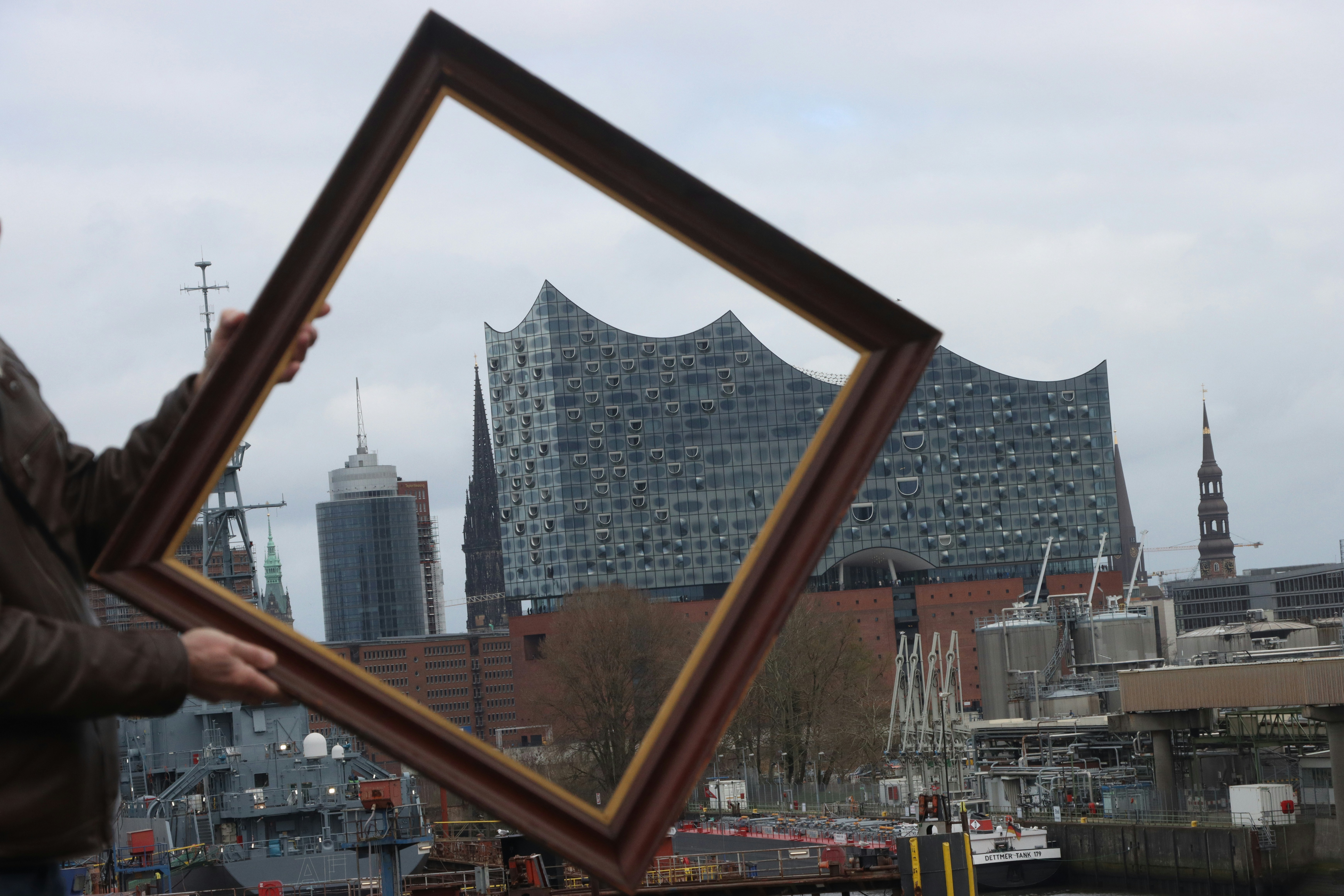 a person holding a picture frame with a city in the background