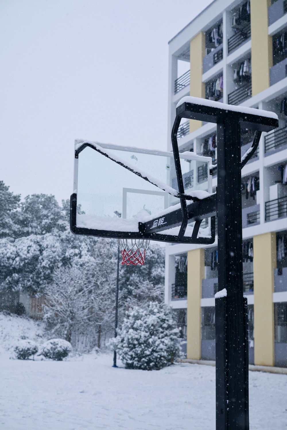 a basketball hoop in front of a building in the snow