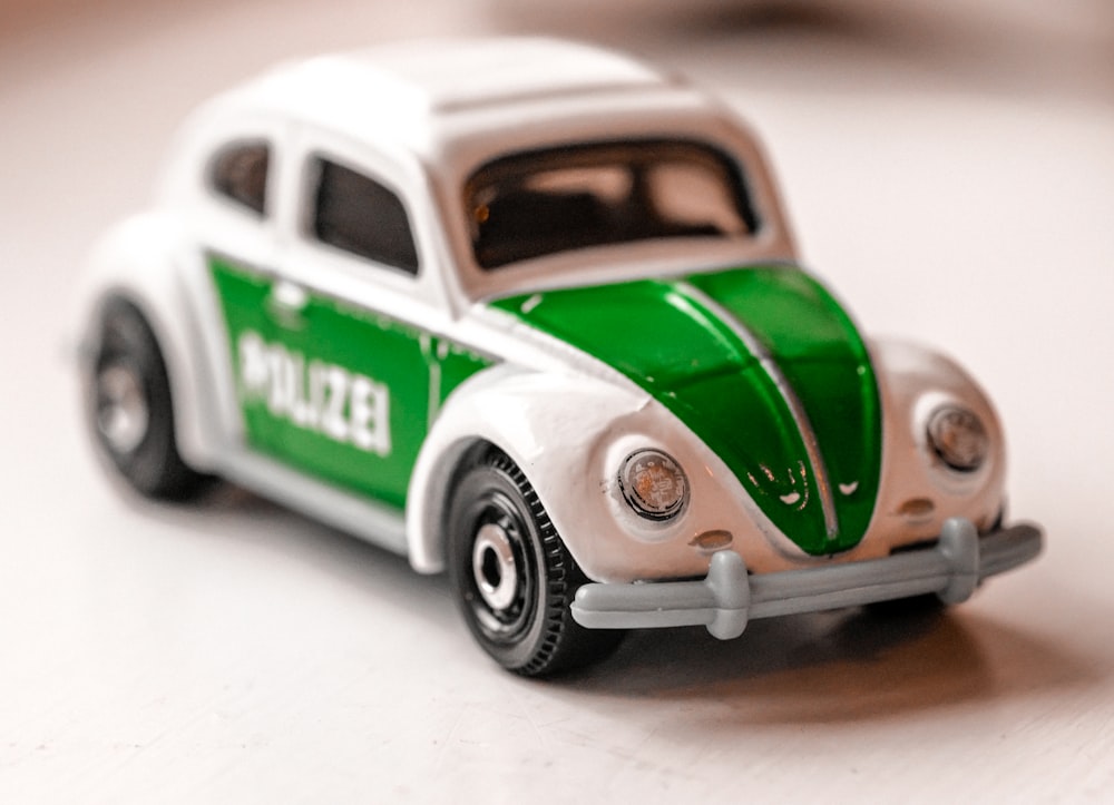 a green and white toy car sitting on a table