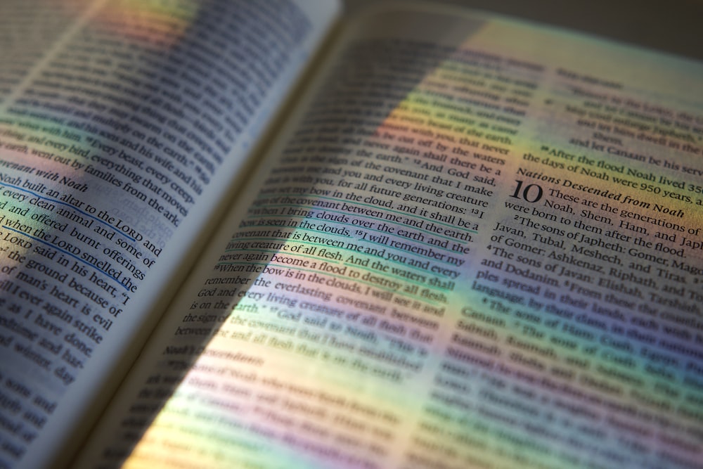 Un primer plano de un libro con una luz de arco iris que sale de él