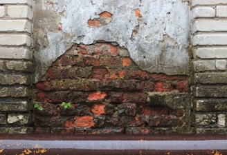 a red fire hydrant sitting next to a brick wall