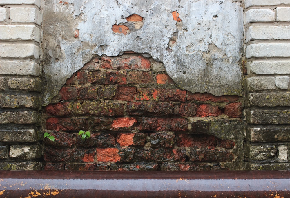 a red fire hydrant sitting next to a brick wall