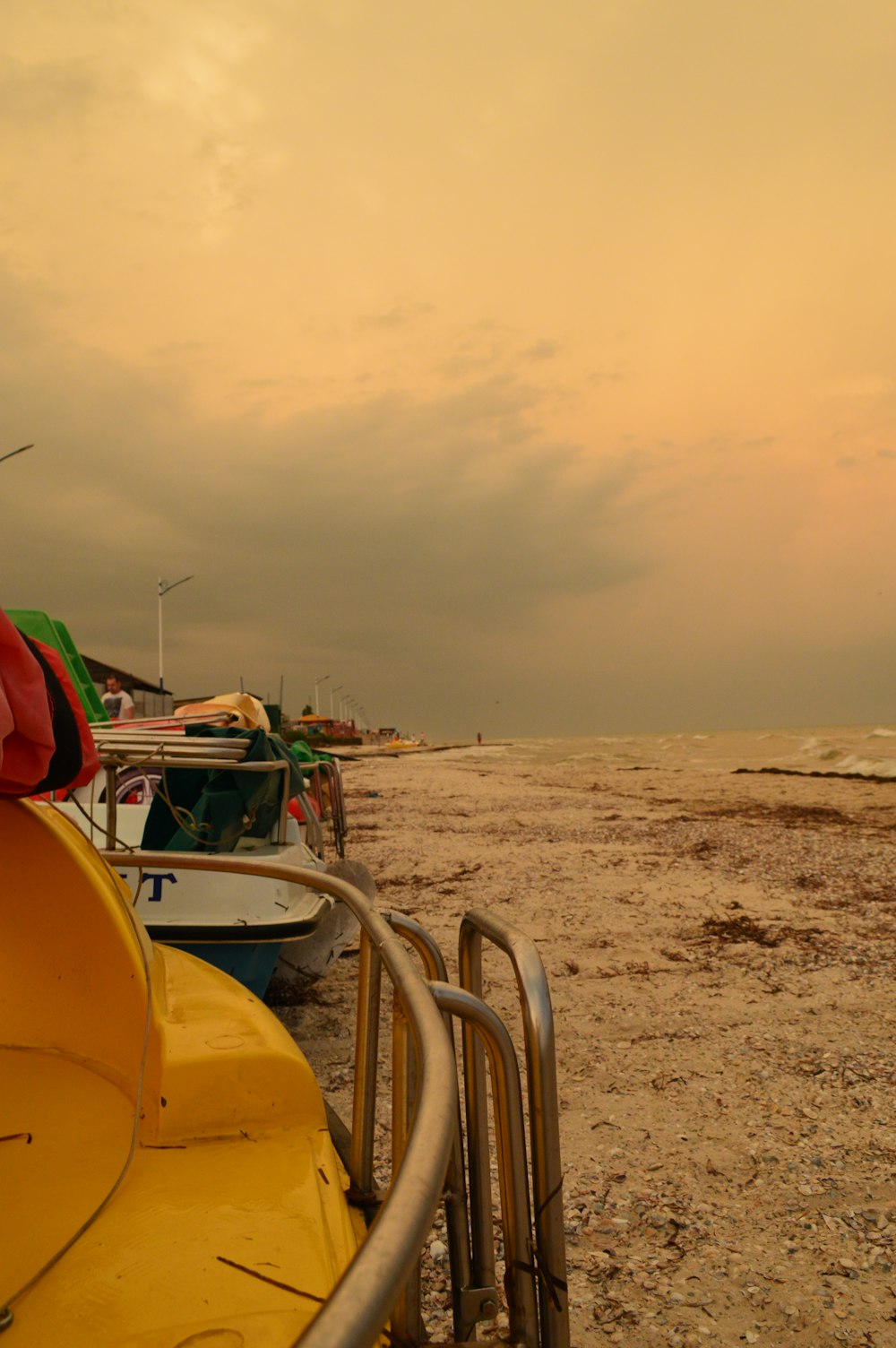 a row of boats sitting on top of a sandy beach