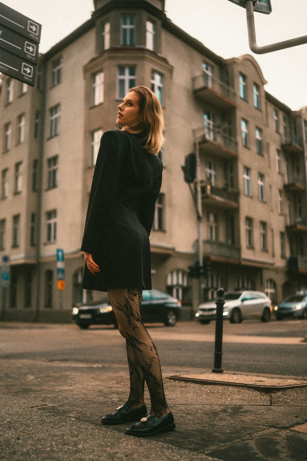 a woman standing on the side of a road