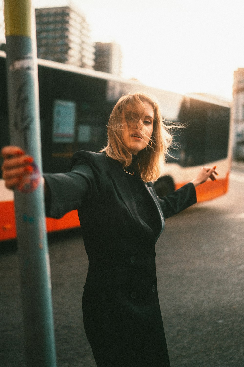 a woman standing next to a bus on a street