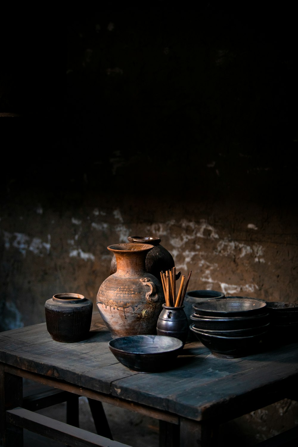 a wooden table topped with plates and a vase