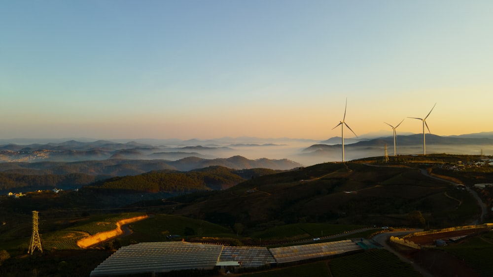 uma vista de um parque eólico ao pôr do sol