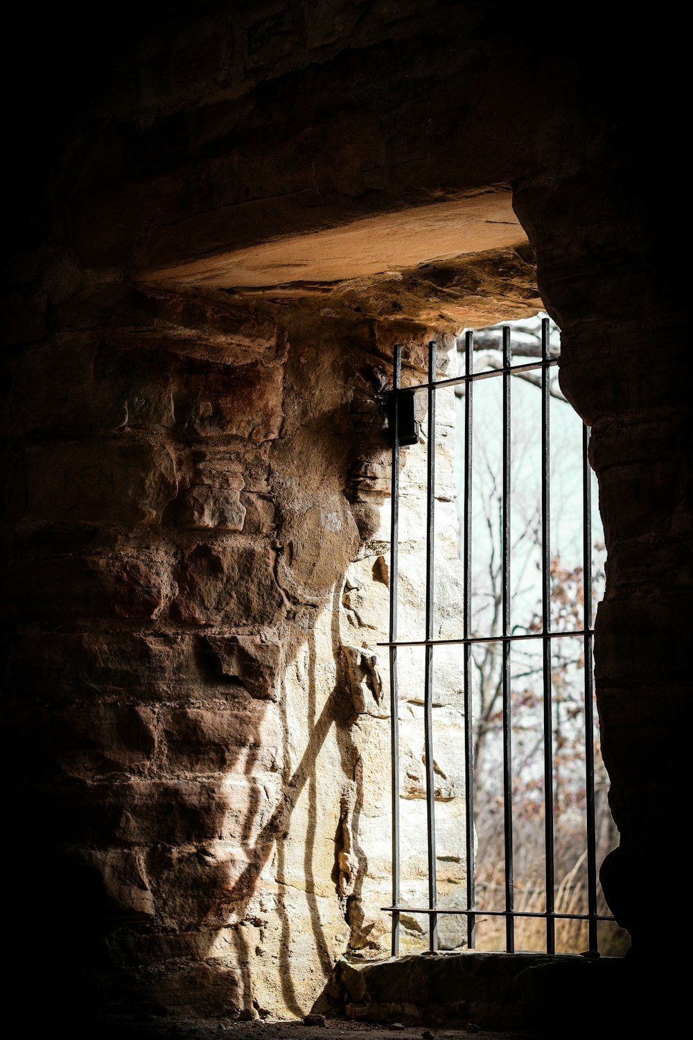 a window in a stone wall with bars on it