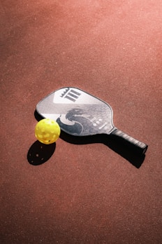 a tennis racket and ball on a court