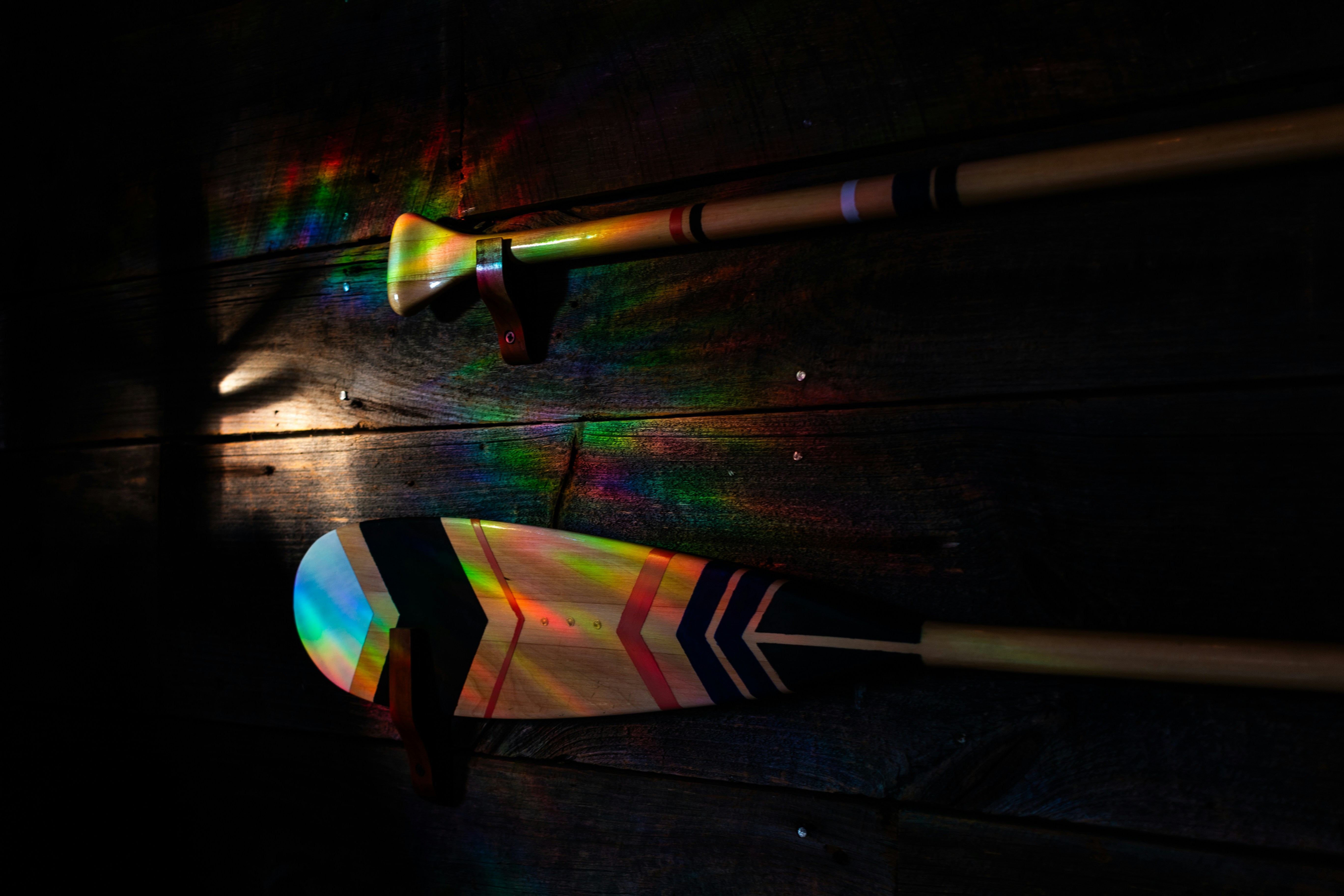 a pair of arrows and a rainbow light on a wall
