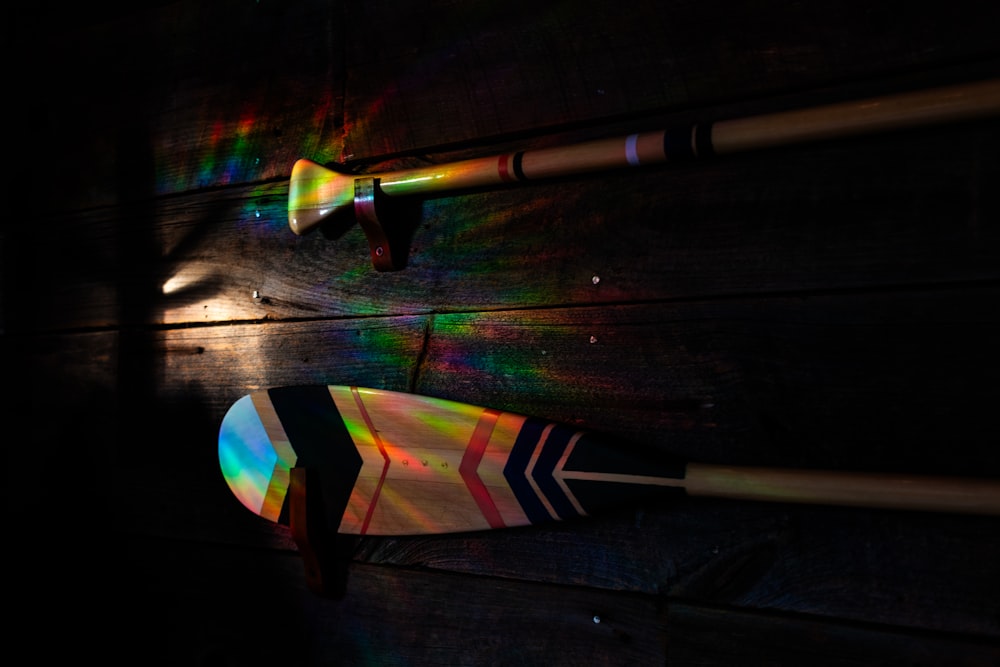 a pair of arrows and a rainbow light on a wall