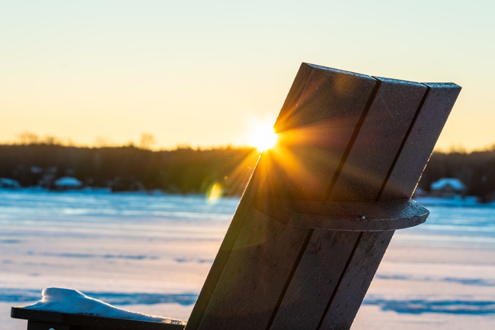 a wooden bench sitting on top of snow covered ground