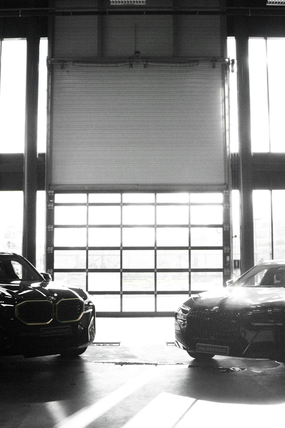 two cars parked in a garage next to each other