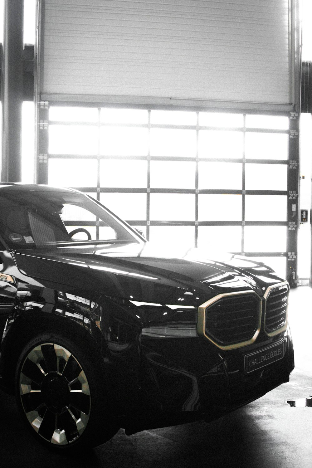 a black car parked in a garage next to a garage door