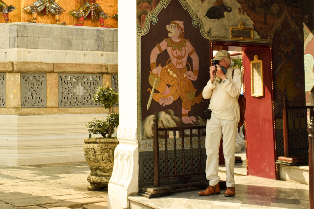a man taking a picture of himself in front of a temple