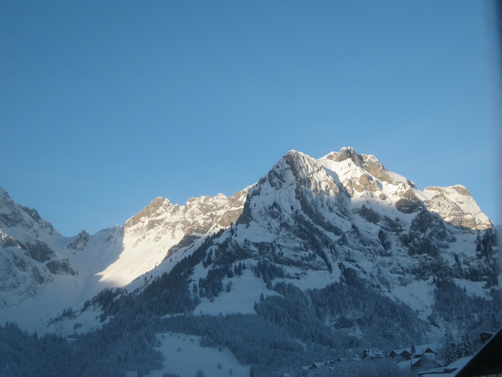 a view of a snowy mountain range from a train window