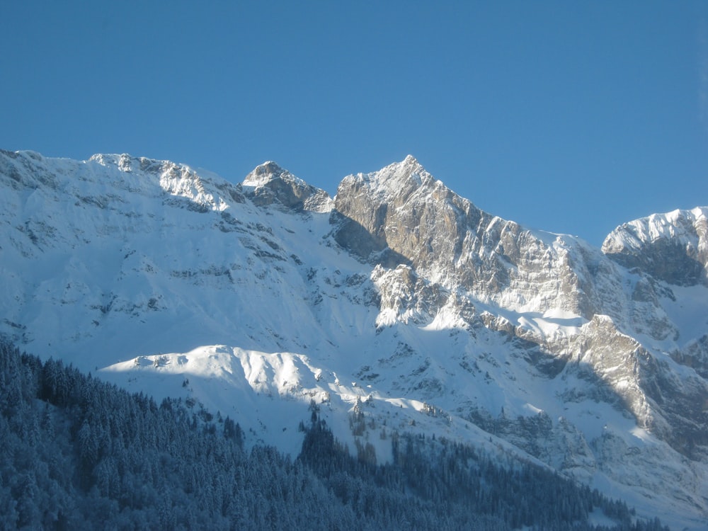 a mountain covered in snow with a sky background