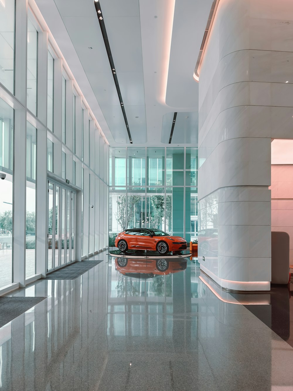 an orange car is parked in a large building