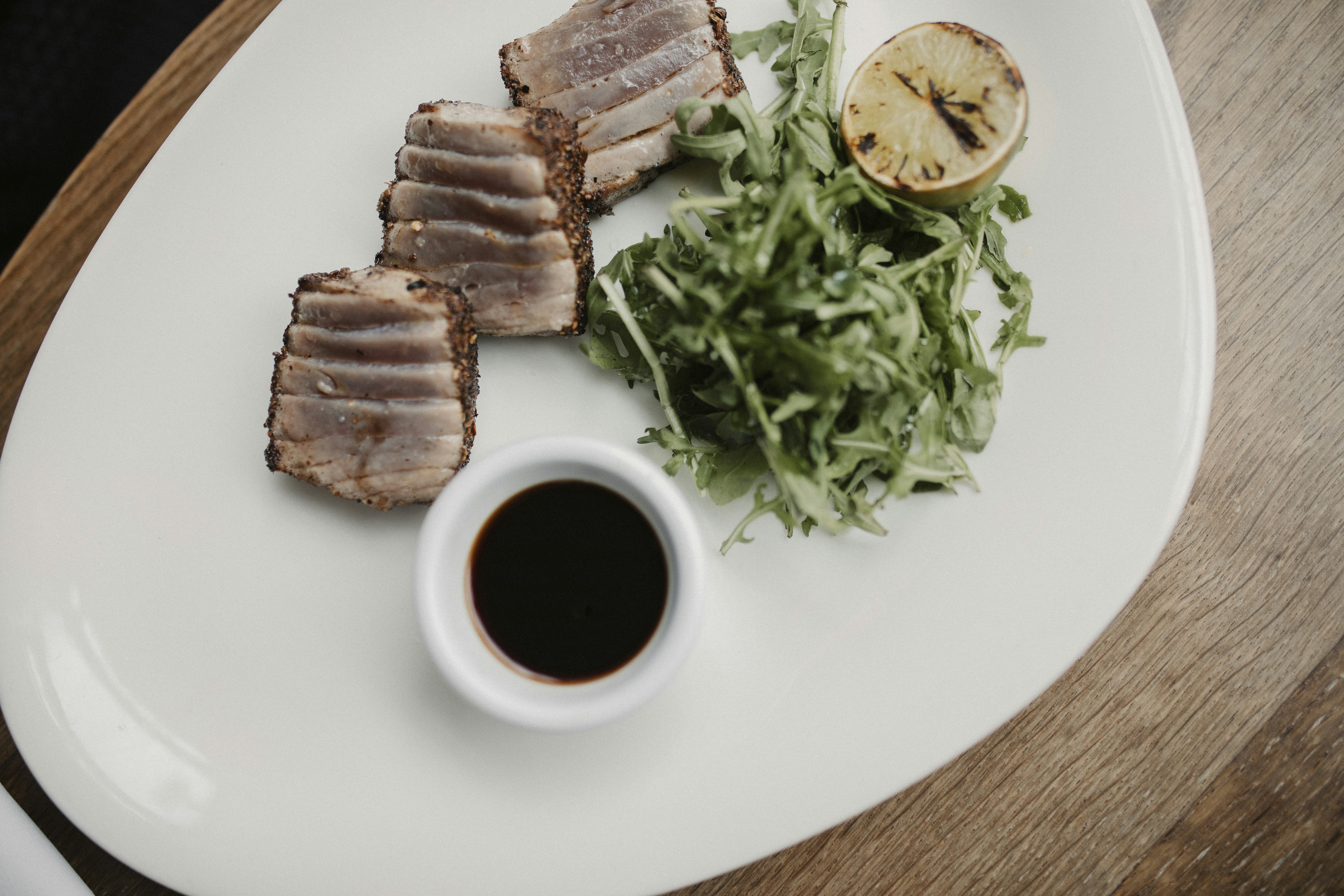 a white plate topped with meat and a salad