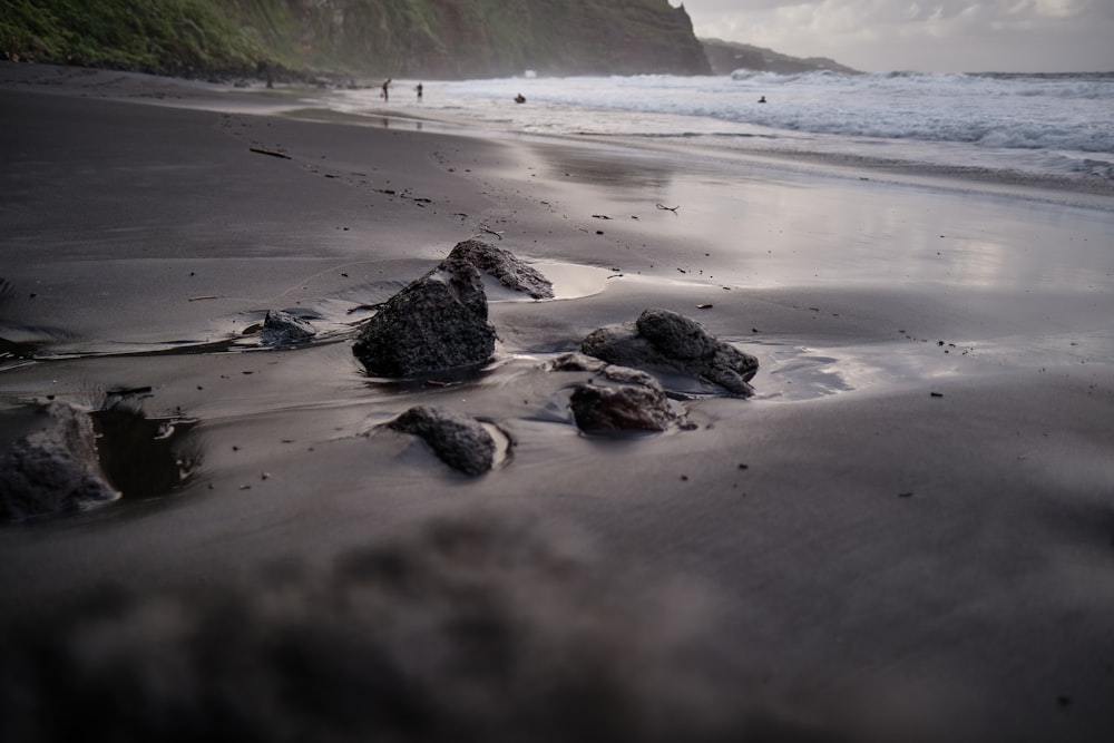 砂浜に岩があり、背景に崖があるビーチ