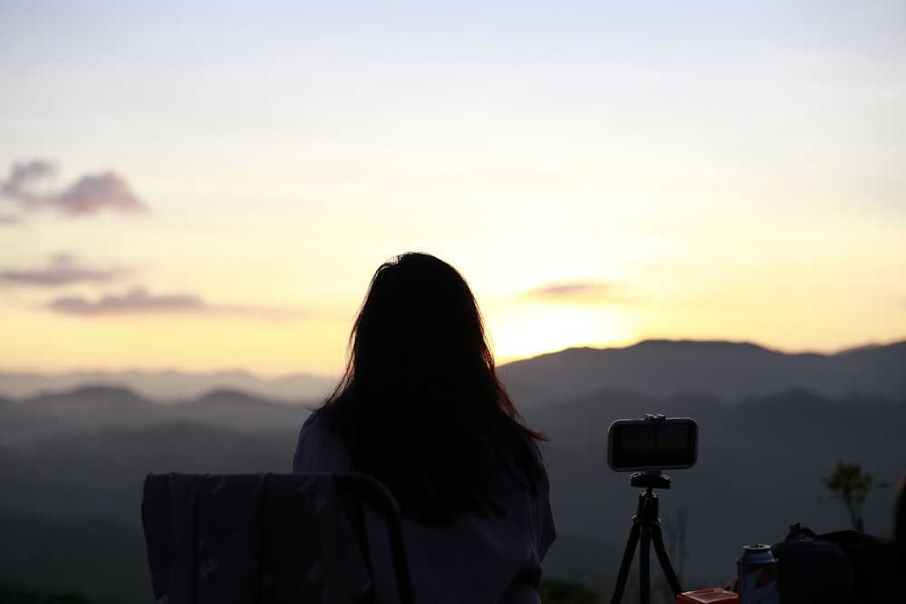 a woman sitting in a chair in front of a camera