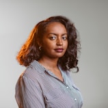 a woman with curly hair wearing a striped shirt