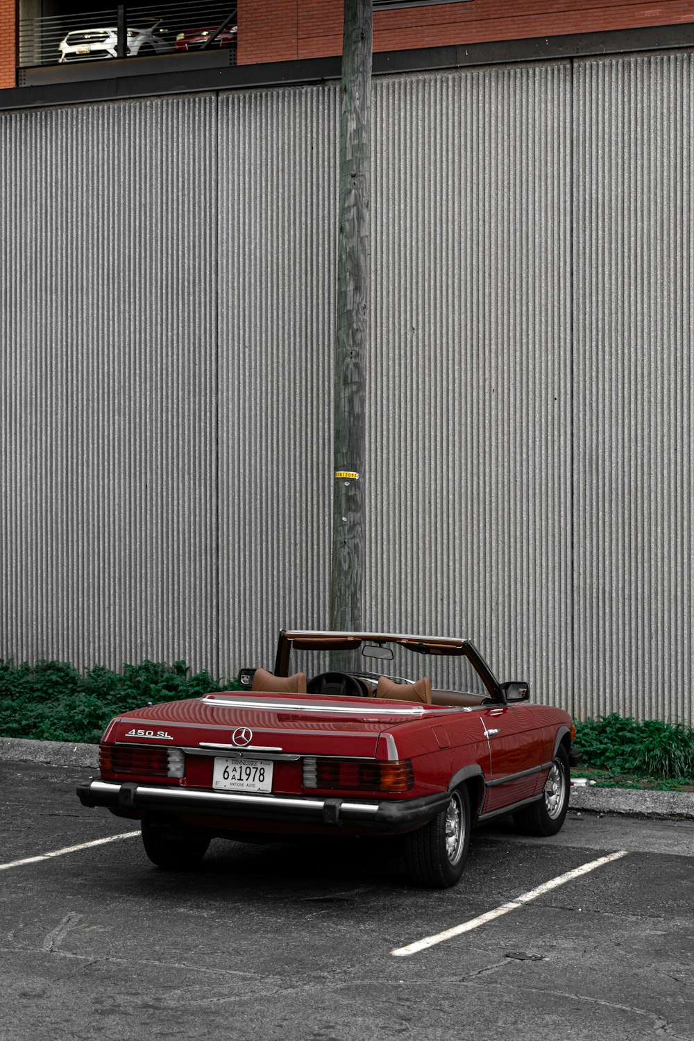 a red convertible car parked in a parking lot