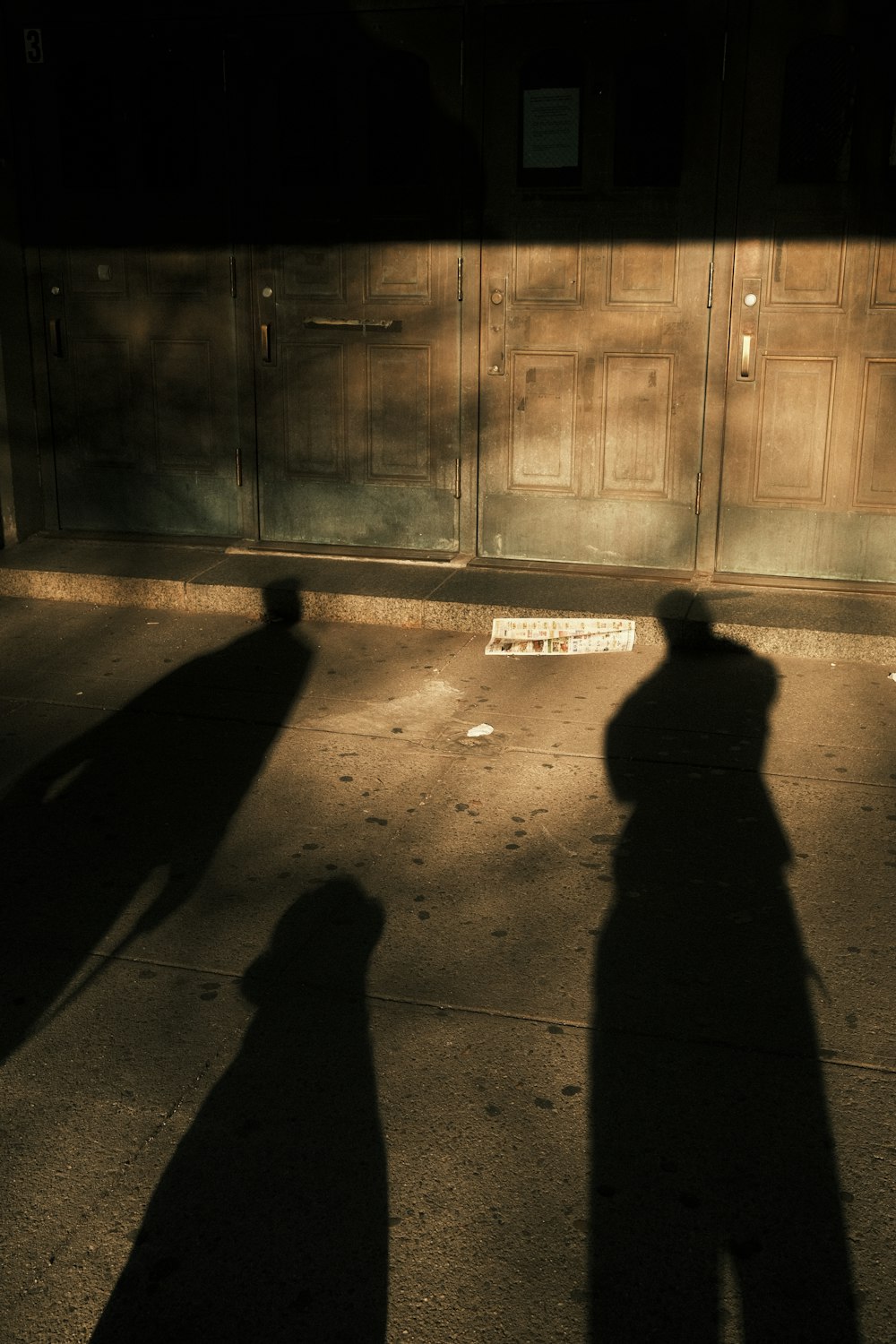 a shadow of two people on a sidewalk