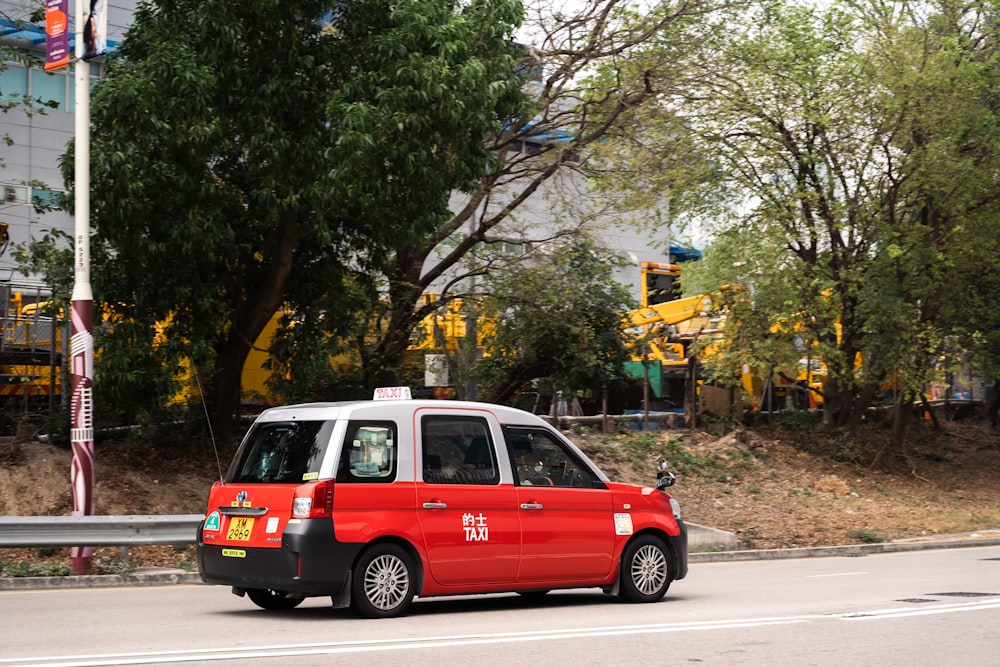 uma minivan vermelha e branca dirigindo por uma rua