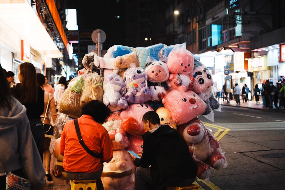 a large pile of stuffed animals sitting on the side of a street