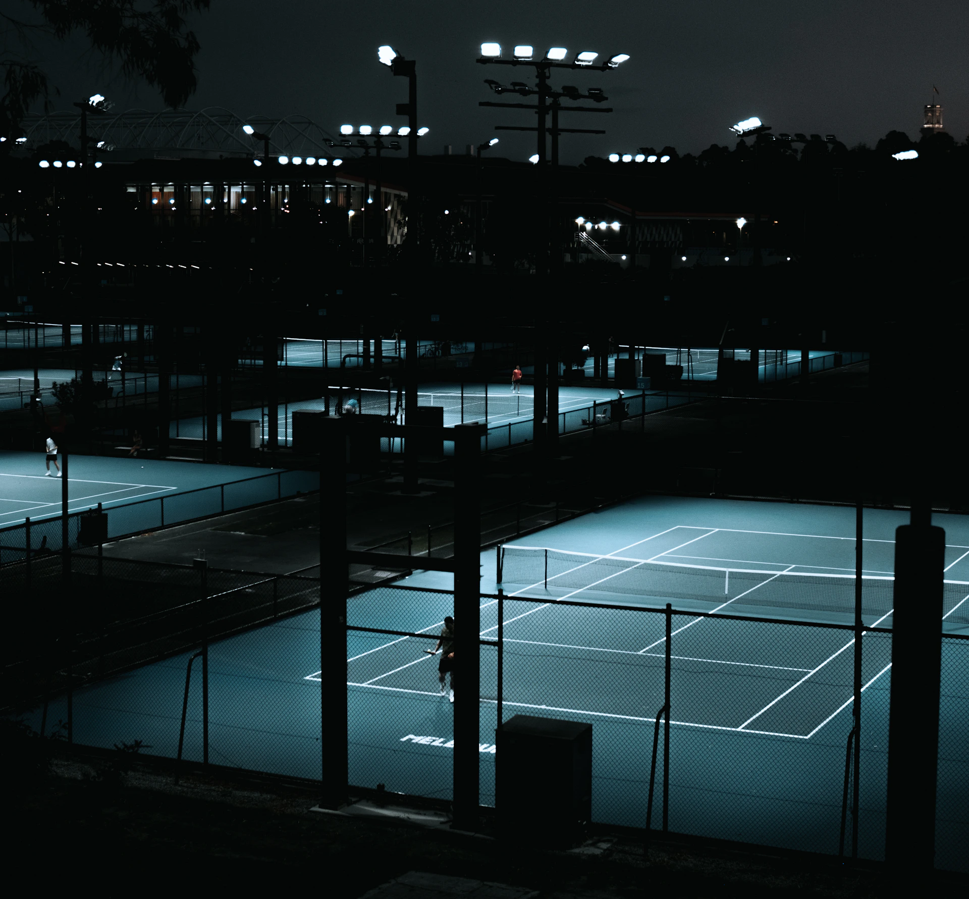 a tennis court lit up at night with lights