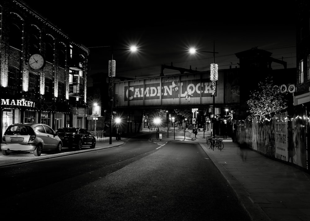 a black and white photo of a street at night