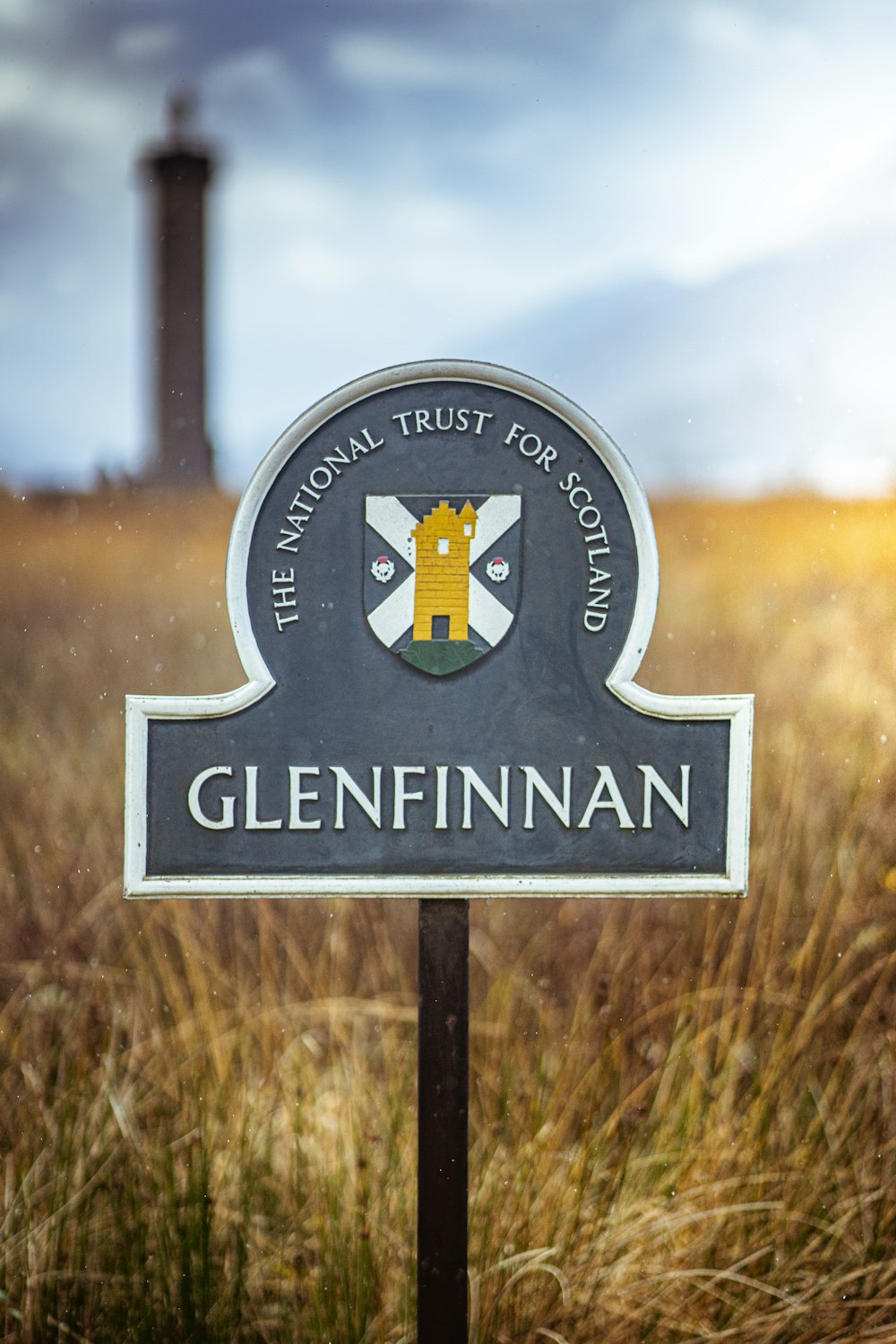 a sign for the national trust for scotland in a field