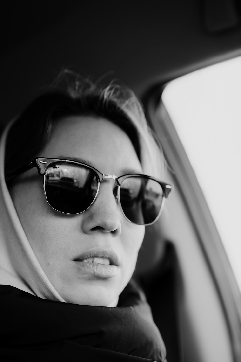 a woman wearing sunglasses sitting in a car