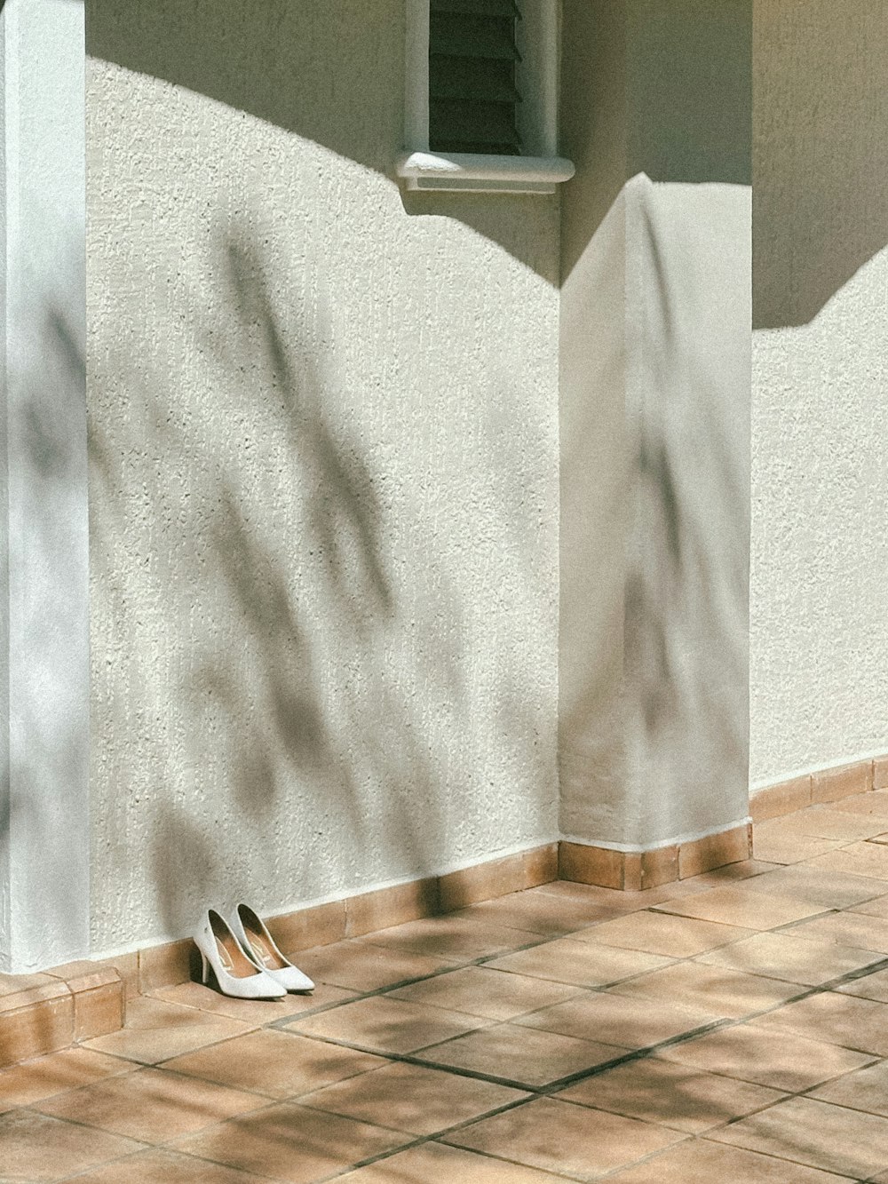 a pair of shoes sitting on the ground next to a building