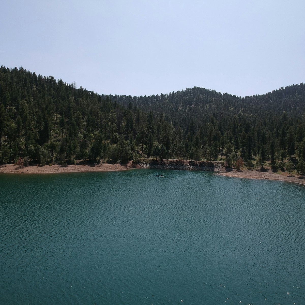 Alto Lake seen level from the shoreline, ringed by pines.