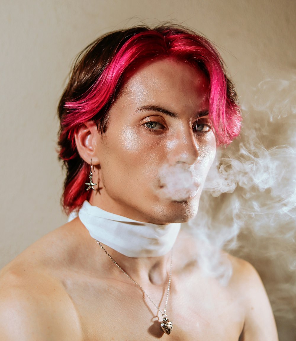 a woman with pink hair smoking a cigarette