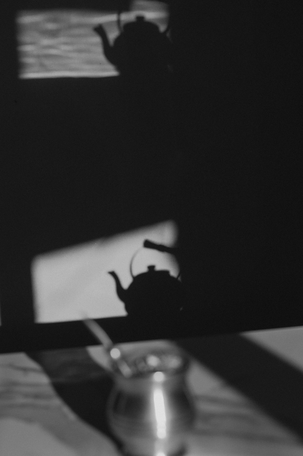 a black and white photo of a teapot on a table