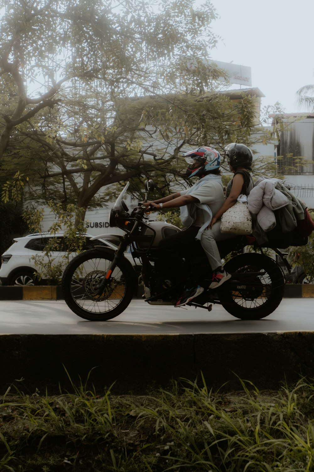 a man and a woman riding on the back of a motorcycle
