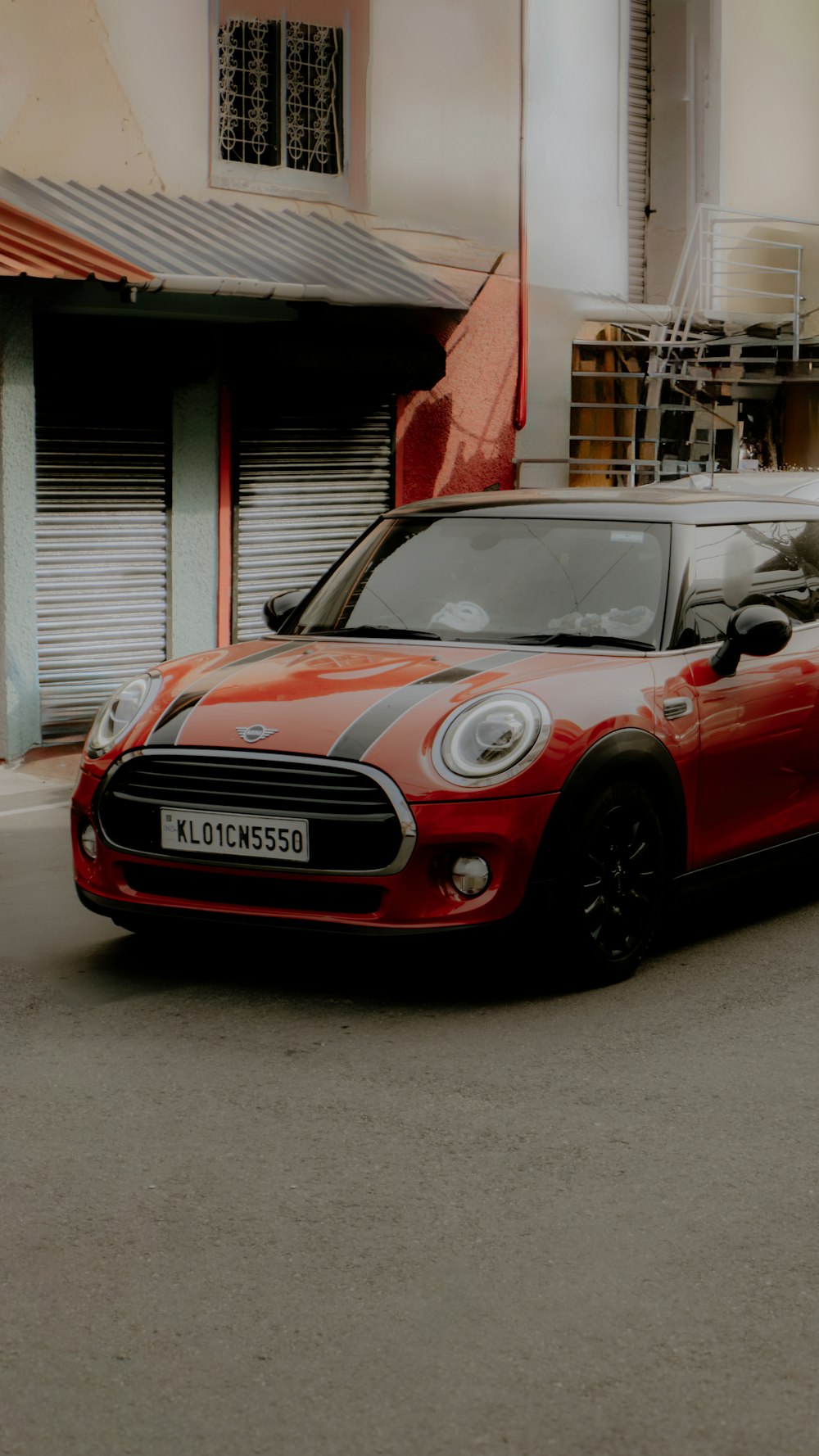 a small red car parked on the side of the road