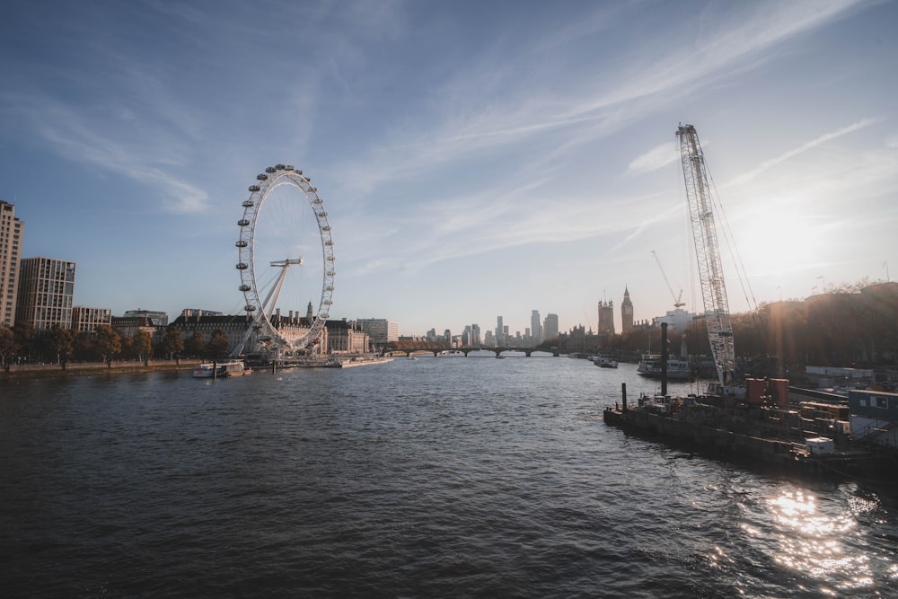 a large ferris wheel towering over a city next to a river