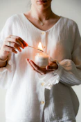 a woman holding a lit candle in her hands