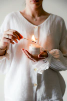 a woman holding a lit candle in her hands