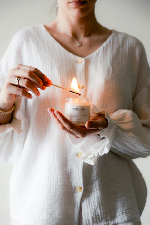 Hands holding a softly glowing candle