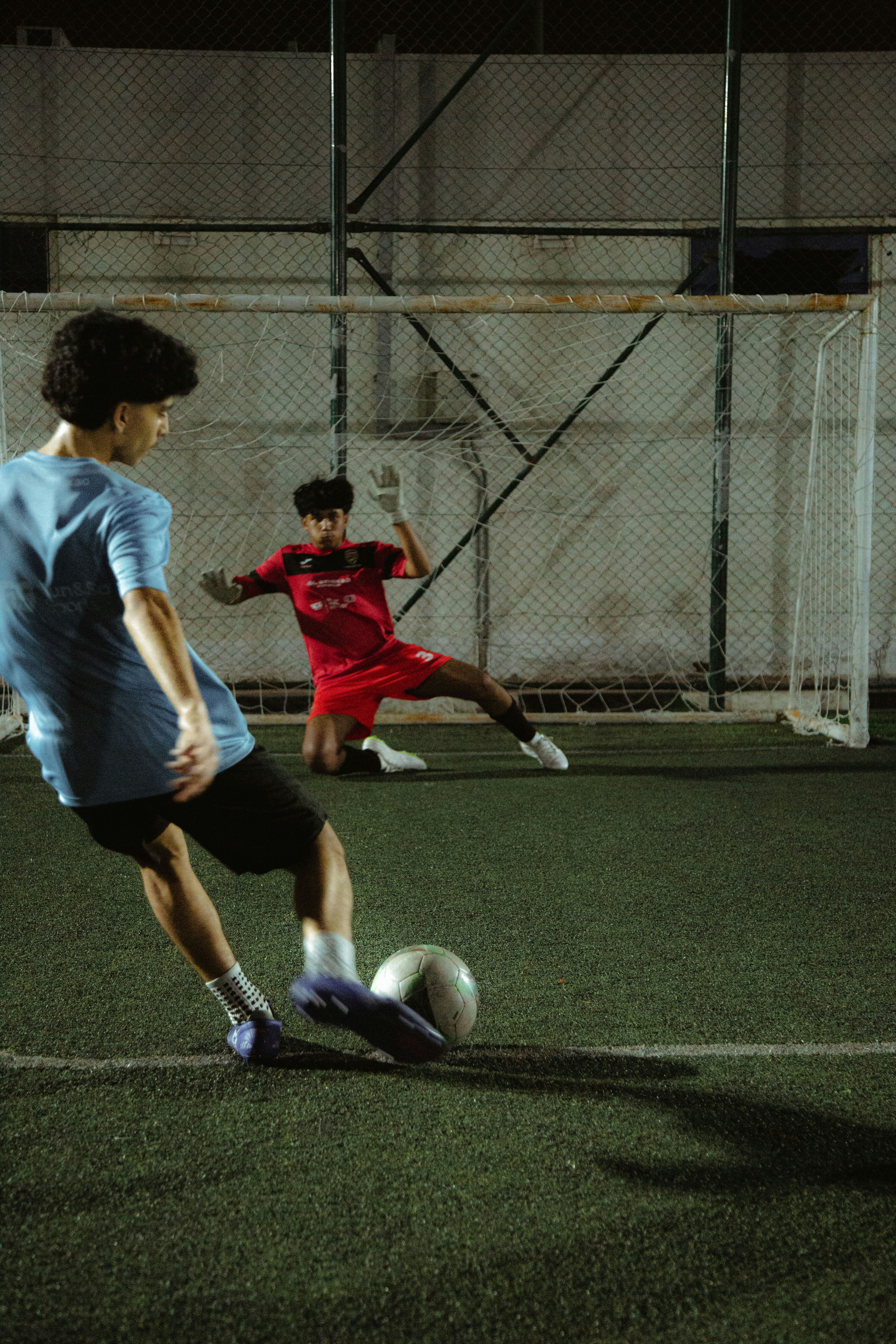 a couple of young men kicking around a soccer ball