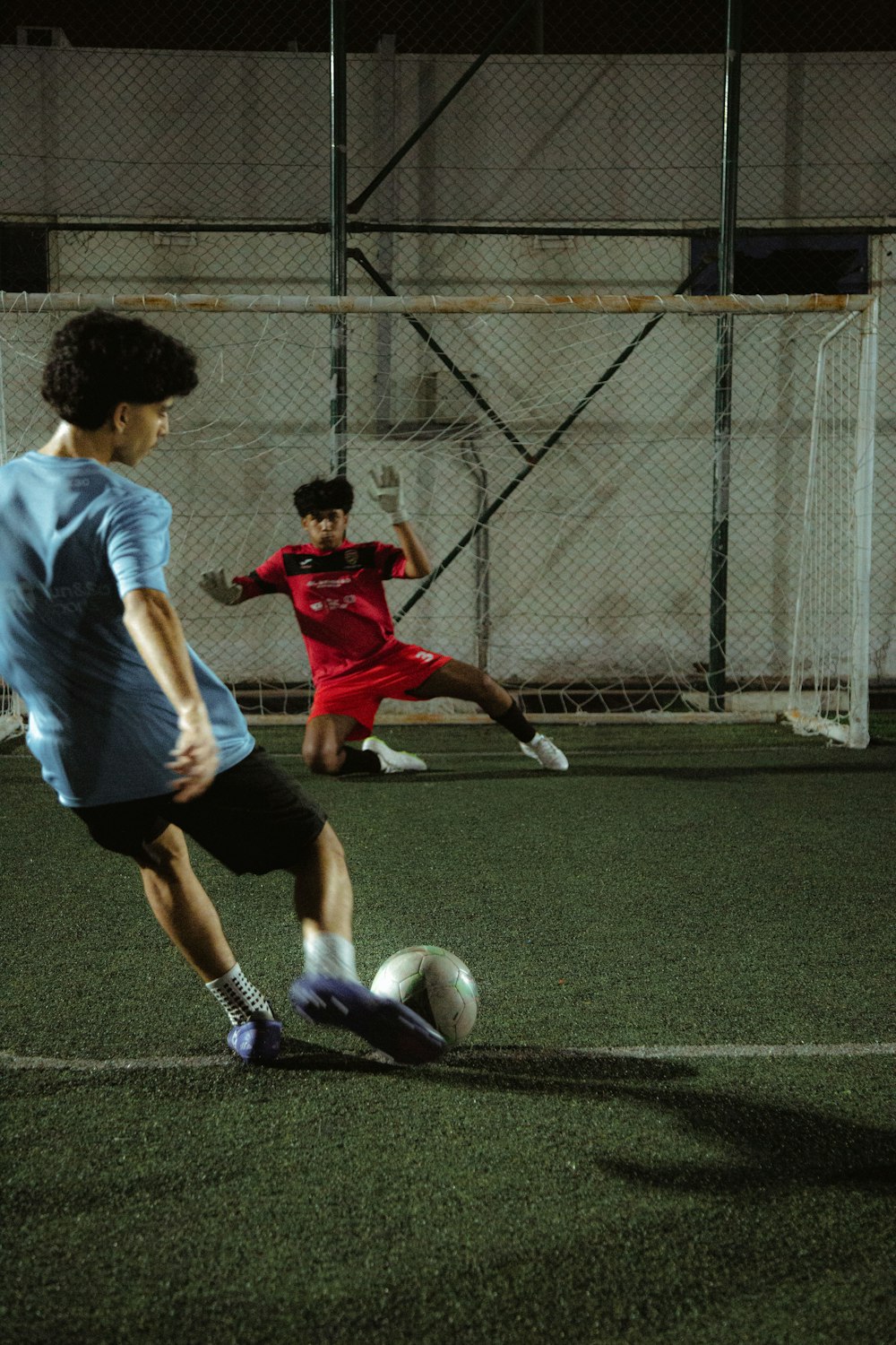 a couple of young men kicking around a soccer ball